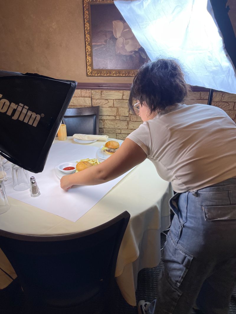 Our photographer styling plates under studio lights during a client shoot